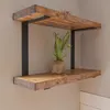Two wooden shelves with black metal brackets mounted on a light gray wall. Produktbild-Vorschau