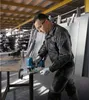 A man is using a Bosch jigsaw to cut metal in a workshop. Produktbild-Vorschau