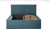 A teal upholstered bed frame with its storage compartment open, revealing a slatted mattress base. Produktbild-Vorschau