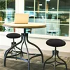A laptop on a round table with two black stools in front of a large window. Produktbild-Vorschau