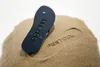 A flip-flop is placed on a pile of sand, with its imprint visible in the sand. Produktbild-Vorschau