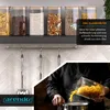 A kitchen scene showing glass storage jars filled with food items on a shelf, with a person pouring pasta into a pot. Produktbild-Vorschau