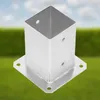 A metal post anchor is shown against a blurred background of green grass and a blue sky. Podgląd zdjęcia produktu