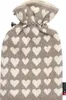 A beige hot water bottle with a white heart pattern, tied at the top with a black and white cord. Produktbild-Vorschau