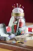A sewing kit is organized inside a glass jar with a pin cushion lid, surrounded by sewing supplies. Podgląd zdjęcia produktu
