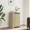 A wooden sideboard with books and a plant on top, placed in a room with a large plant and a sofa visible. Anteprima dell’immagine prodotto