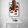 A retro-style chandelier with four lantern-shaped lights hangs above a white wooden dining table with white chairs. Náhled obrázku produktu