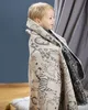 A young child wrapped in a blanket with a safari animal print. Produktbild-Vorschau