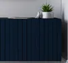 A close-up view of a navy blue dresser with a plant and a decorative bird on top. Produktbild-Vorschau