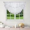 A white valance curtain with silver trim and star-like embellishments hangs over a window with a view of green trees and grass. Below the window, on a pink surface, are decorative items including a vase with flowers, books, a gold lamp, and two white bottl Podgląd zdjęcia produktu