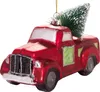 A close-up studio shot of a red glass Christmas ornament shaped like a pickup truck with a small green Christmas tree in the bed. Voir les images du produit