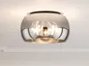 A ceiling lamp with a glass shade is mounted on a white ceiling. Produktbild-Vorschau
