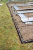 Construction site for a greenhouse or garden structure, with parts laid out on the ground. Produktbild-Vorschau