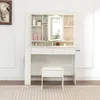 A white vanity table with a mirror and stool, set against a white wall and a striped rug. Produktbild-Vorschau