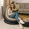 A young woman is sitting in an inflatable chair reading a book. Produktbild-Vorschau