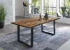 A dining room with a wooden table and chairs, a rug, and a large window. Produktbild-Vorschau
