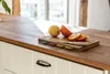 A kitchen counter with a cutting board, fruit, and a knife. Anteprima dell’immagine prodotto