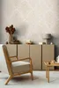 A living room scene with a chair, cabinet, and side table, showcasing wallpaper. Produktbild-Vorschau