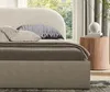 A close-up view of a bed with pillows and a bedside table next to a window. Anteprima dell’immagine prodotto