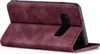 A burgundy flip cover case for a smartphone is shown from the side, with the phone inside and the cover partially open. Produktbild-Vorschau