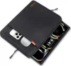 A black laptop and tablet sleeve with a phone and earbuds partially inserted. Produktbild-Vorschau