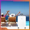 Two people relaxing on lounge chairs by the sea with a suitcase. Produktbild-Vorschau