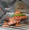 A close-up shot of a steak being grilled on a barbecue, with rosemary sprigs on top. Produktbild-Vorschau