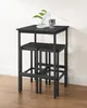 A black bar table and two stools are placed in front of a white wall. Produktbild-Vorschau