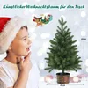 A young boy in a Santa hat looks at a small artificial Christmas tree on a table, with festive bokeh lights in the background. Produktbild-Vorschau