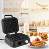 A waffle maker is shown open on a kitchen counter, with ingredients and finished waffles nearby. Náhľad obrázku produktu