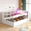 A white multifunctional bed with storage and LED lighting, shown in a room setting with decorative items and a rug. Produktbild-Vorschau