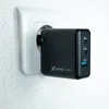 A black Xlayer 65W USB-C charger plugged into a white wall socket. Náhľad obrázku produktu