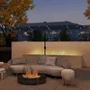 An outdoor patio scene at dusk with a curved sofa, fire pit, and a large umbrella with lights. Produktbild-Vorschau