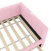 Close-up view of a pink upholstered bed frame with wooden slats. Podgląd zdjęcia produktu