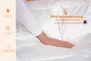 A person's hand is touching a white, fluffy duvet or comforter, highlighting its texture and features. Produktbild-Vorschau