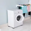 A white washing machine in a laundry room with clothes hanging on a drying rack in the background. Produktbild-Vorschau