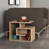 A modern wooden side table next to a sofa, with books and a plant on it. Produktbild-Vorschau
