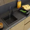 A modern kitchen sink area with a black sink, faucet, and wooden accents. Podgląd zdjęcia produktu