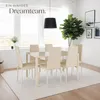 A dining room setting with a table and chairs, a large plant, and artwork on the wall. Náhled obrázku produktu