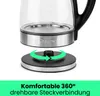 A close-up of a glass electric kettle base and its power stand, with a green arrow indicating 360-degree rotation. Produktbild-Vorschau