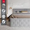 A bed with a tufted headboard and footboard, styled with bedding and pillows, in a bedroom setting with a marble-patterned wall and a bedside table. Produktbild-Vorschau