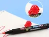 A close-up shot of an acrylic painter marker with its cap displayed on top of the marker on a white surface with some red markings. In the background is a light blue surface. Náhľad obrázku produktu