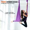 A woman is performing aerial yoga in a studio with large windows. Podgląd zdjęcia produktu