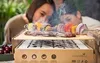 Two people are grilling food on a disposable grill outdoors. Produktbild-Vorschau
