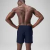 A man wearing navy blue swim shorts, viewed from the back. Produktbild-Vorschau