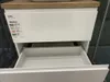 A close-up view of a white bathroom vanity with an open drawer, showing a label with product information. Podgląd zdjęcia produktu