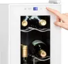 A hand is shown pressing a button on the control panel of a white wine cooler, which contains several bottles of wine. Náhľad obrázku produktu