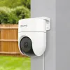 A white EZVIZ H8c security camera is mounted on a light gray wall, overlooking a green lawn and a wooden fence. Produktbild-Vorschau