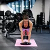 A woman is doing a plank exercise on a balance pad in a gym. Produktbild-Vorschau