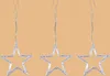 Three silver star-shaped ornaments hanging from thin strings against a plain light orange background. Produktbild-Vorschau